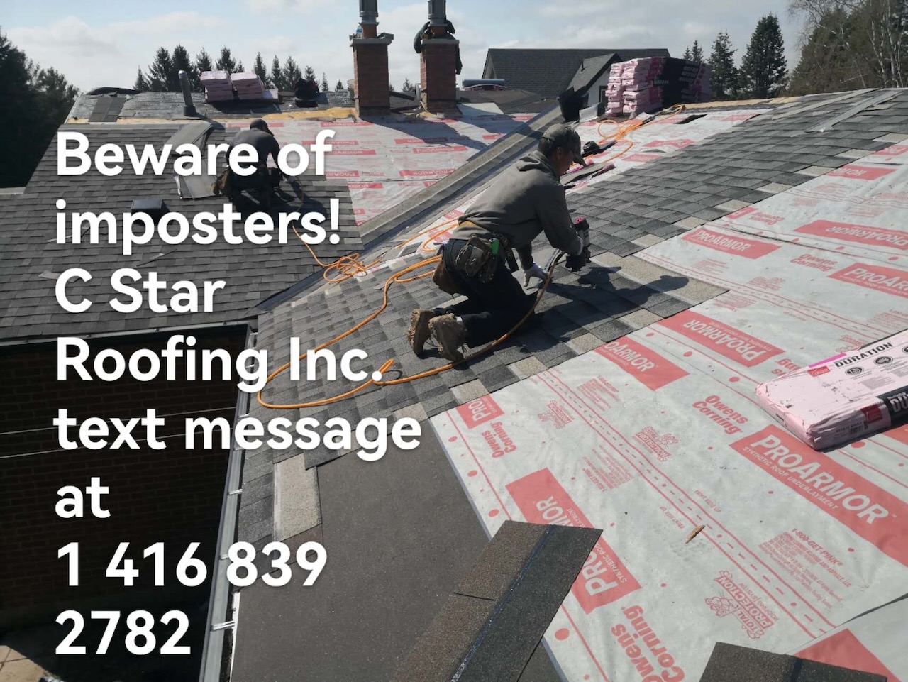 Roofer nailing architectural shingles over new underlayment beside brick chimneys