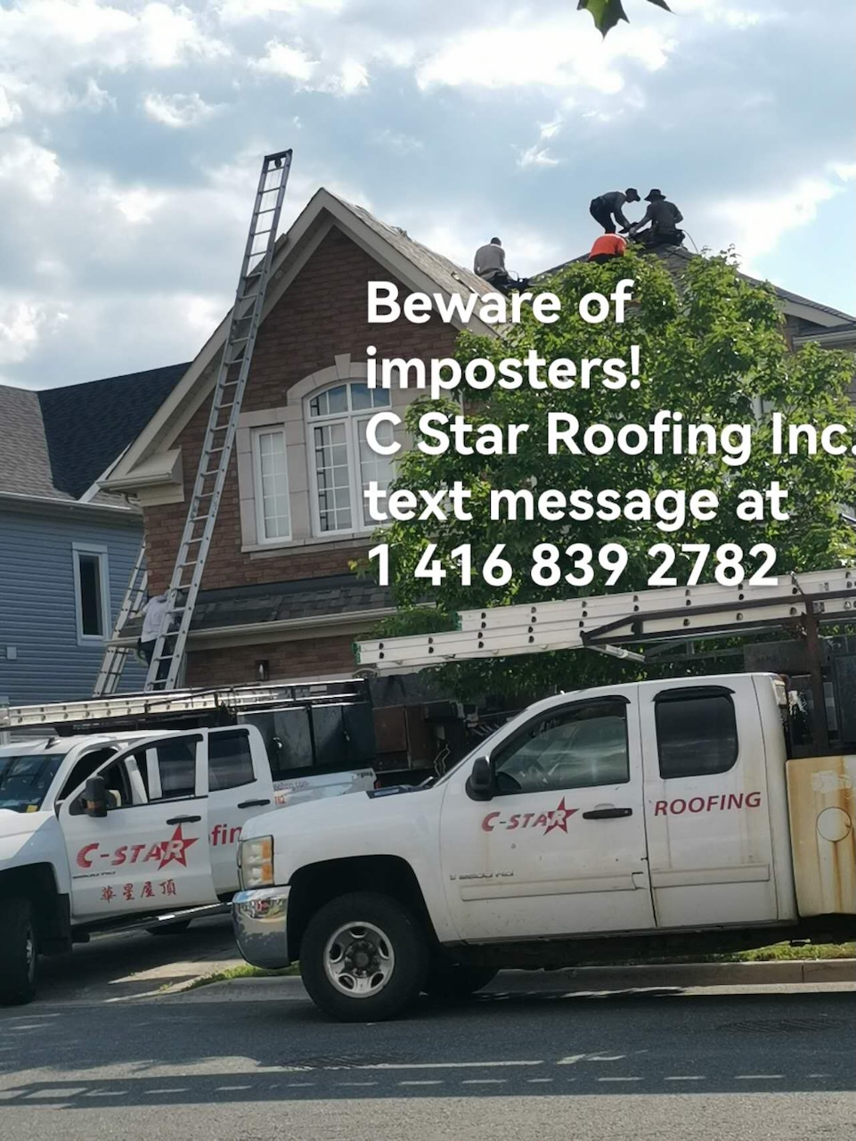 C-Star Roofing crew working on a brick home with company trucks parked out front